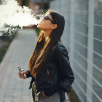 stylish girl smoking an e-cigarette