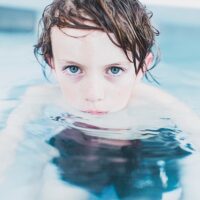 Young boy in a pool, representing the need for a West Virginia swimming pool injury attorney when accidents occur.